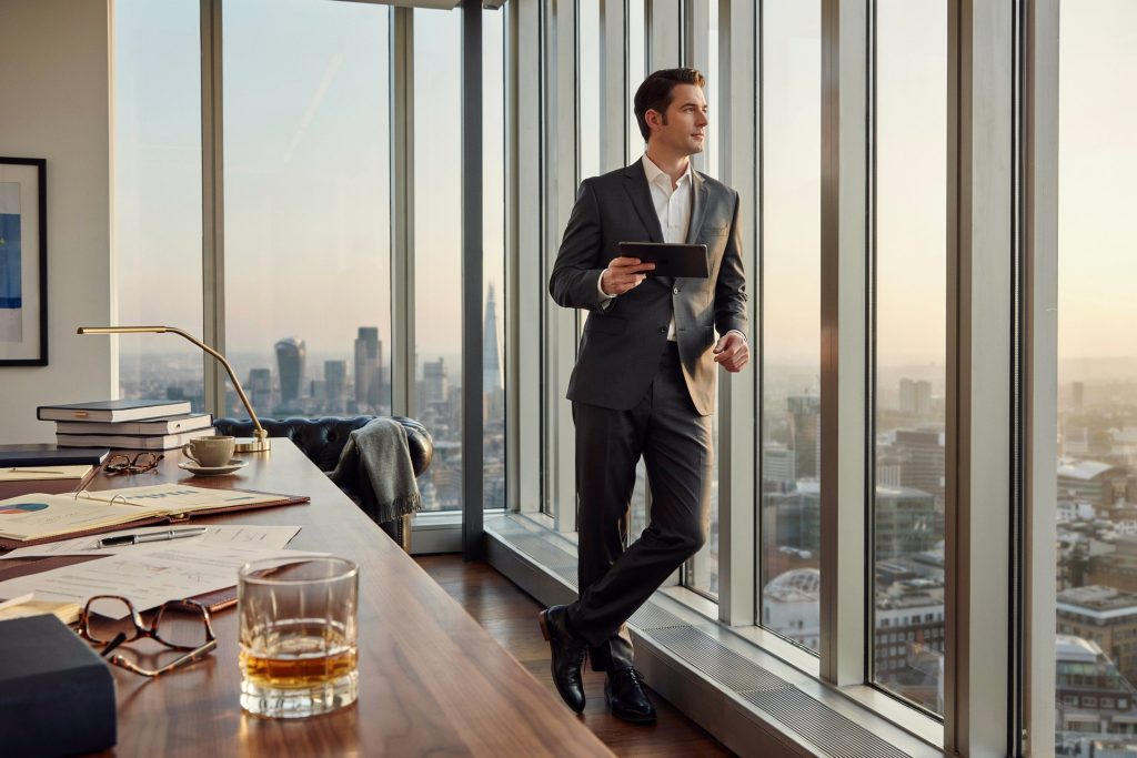 Alex Cowper-Smith inspired businessman in a modern financial workplace.